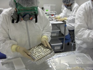 Lab personnel handle tablets used in clinical trials.